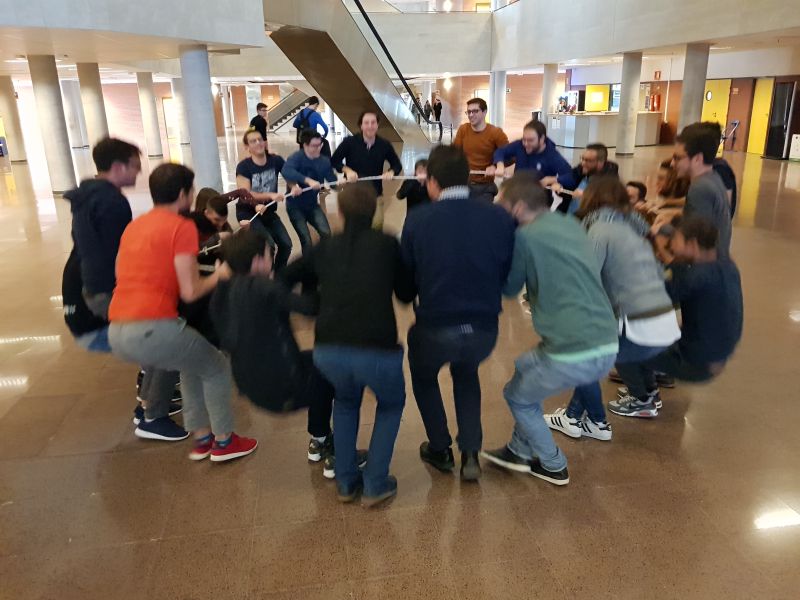 En un aula magna semicircular una persona está hablando y en los pupitres otras personas escuchando