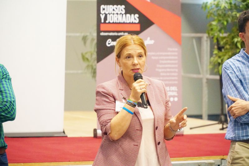 Una mujer hablando con un microfono Equipos